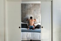 Apaixonado sexual feliz sem camisa gay casal em um momento íntimo na cama em casa — Fotografia de Stock