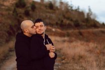 Romantic homosexual couple embracing on route in nature — Stock Photo