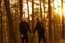 Casal homossexual de mãos dadas e caminhando no caminho na floresta — Fotografia de Stock