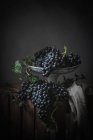 Bunch of grapes on metal vintage plate on dark background — Stock Photo