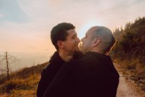 Щаслива гомосексуальна пара обіймає шлях у лісі в сонячний день — стокове фото