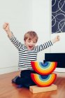 Rubia lindo chico jugando con waldorf arco iris rompecabezas - foto de stock
