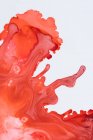 Abstraction de peintures liquides en mélange lent mélangeant ensemble sur fond blanc — Photo de stock