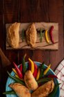 Hausgemachte Pasteten und frische grüne und rote Chilischoten auf grauem Holztisch — Stockfoto