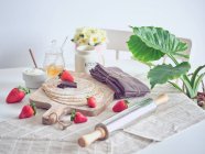 Café da manhã com panquecas e morangos na mesa da cozinha com flores — Fotografia de Stock