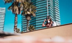 Teenie-Mädchen beobachtet die Straße, während sie mit Helm und Smartphone Musik hört — Stockfoto