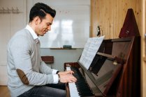 Bonito homem tocando piano durante o ensaio em estúdio de gravação
. — Fotografia de Stock
