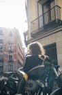Mujer joven en moto personalizada - foto de stock