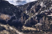 Dall'alto splendida vista del sentiero tra alte colline rocciose con piante verdi nella giornata di sole — Foto stock