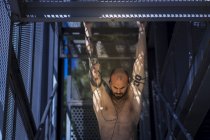 Muscular guy performing pull ups in stairway — Stock Photo