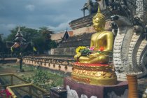 Золота статуя Будди біля старого храму — стокове фото