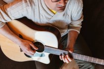 Close-up of man playing guitar on dark background — Stock Photo