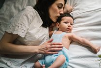 Мати і дитина лежать на ліжку — стокове фото