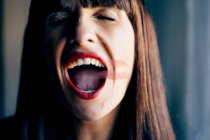 Attraente femmina con bocca aperta e labbra rosse baciare vetro trasparente pulito con passione — Foto stock