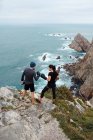Мужчина и женщина в боксёрских перчатках стоят на скале у моря — стоковое фото