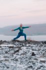 Блондинка тренируется на снежном берегу в природе — стоковое фото