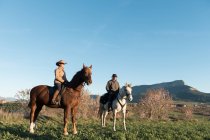 Мужчина и женщина верхом на лошадях на ранчо — стоковое фото