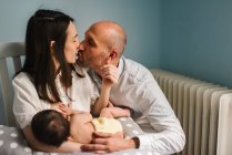 Pais felizes alimentando bebê — Fotografia de Stock