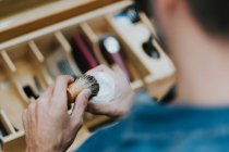 From above crop male with brush and shaving cream near equipments in barbershop on blurred background — Stock Photo
