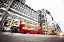 Bus on road near modern building with glass facade — Stock Photo