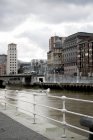 Cloudy sky over buildings and canal in city, Bilbao, Spain — Stock Photo