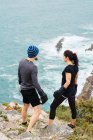 Homme et femme en gants de boxe debout sur une falaise contre la mer — Photo de stock