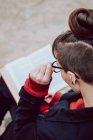Jovem mulher elegante em óculos lendo livro ao ar livre — Fotografia de Stock