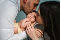 Parents holding baby in room — Stock Photo
