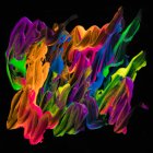 Spills of thick pigment of various colors mixing on black background — Stock Photo