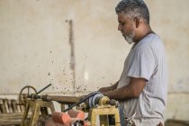 Mature man using woodworking machine in workshop — Stock Photo