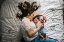 Mother and baby lying on bed — Stock Photo