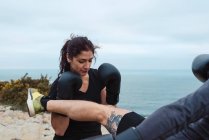 Uomo punzonatura donna in guanti da boxe punzonatura sulla costa del mare — Foto stock