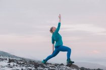 Donna bionda che si esercita sulla montagna innevata nella natura — Foto stock