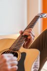 Руки людини, що грає на гітарі на ліжку — стокове фото