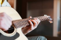 Manos del hombre tocando la guitarra sobre fondo borroso - foto de stock
