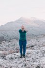 Жінка з молитовними руками медитує у сніжних горах. — стокове фото
