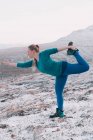 Blond woman exercising in snow mountains — Stock Photo