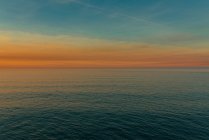 Minimalista paesaggio di acque calme increspate dell'oceano con cielo colorato al tramonto, Spagna — Foto stock