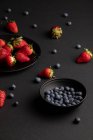 Різні свіжі літні ягоди на чорному тлі — стокове фото