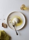 Piatto con deliziosa burrata fresca su tavolo bianco vicino a pezzo di pane e olio con sale — Foto stock