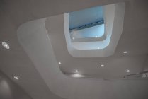 Снизу перспективной современной освещенной лестницы в белом цвете идет спираль — стоковое фото