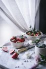 Strawberries and flowers on marble table — Stock Photo