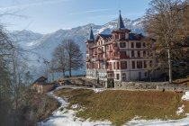 Экстерьер здания курорта среди горного хребта при ярком солнечном свете, Швейцария — стоковое фото