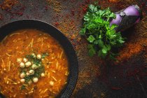 Traditional Harira soup for Ramadan in black bowl on dark tabletop with fresh coriander — Stock Photo