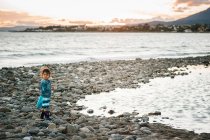 Bonito menina brincando com pedras na praia — Fotografia de Stock