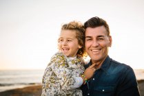Middle aged man with her daughter at sea shore smiling and hugging each other — Stock Photo
