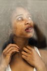 Portrait of sensual black woman behind wet window — Stock Photo