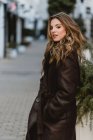 Attractive stylish woman standing on city street — Stock Photo
