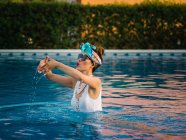 Joven mujer china rica relajarse en la piscina en el complejo de lujo - foto de stock