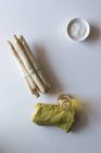 Зелена серветка покладена на білий стіл біля пучка свіжої спаржі з олією та сіллю — стокове фото